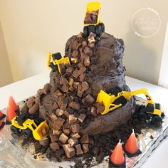 a birthday cake made to look like a pile of dirt with construction vehicles on top