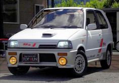 a small white car parked in front of a building