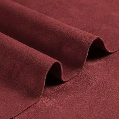 a close up view of the fabric on a plain maroon colored cloth, which is very soft