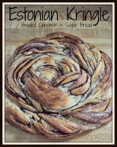 a close up of a loaf of bread on a cutting board with the words, ethiopian kringle braided cinnamon and sugar bread