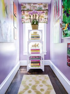 a room with purple walls and pictures on the wall, along with a white rug