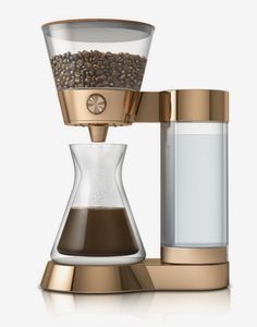 a coffee maker with a glass carafe on the top and some coffee beans in it