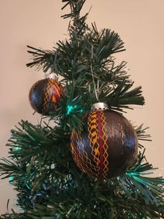 two ornaments are hanging from the top of a christmas tree