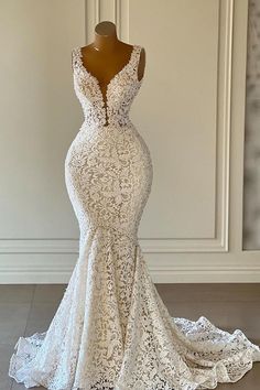 a white wedding dress on a mannequin in front of a wall and floor