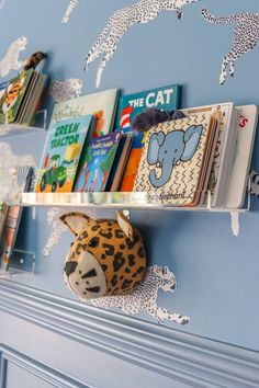 the bookshelf is filled with children's books and stuffed animals on it