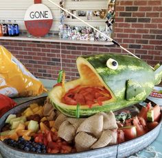 a fish made out of watermelon and other fruits is on display at a store