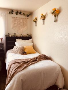 a small bedroom with two twin beds and flowers on the wall above them, along with other decorations