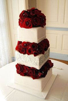 three tiered wedding cake with red roses on top