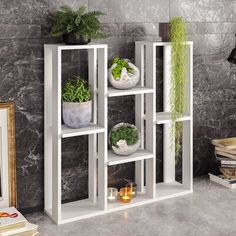 a white shelf with plants on it in a room