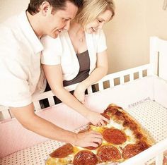 a man and woman are looking at a pepperoni pizza