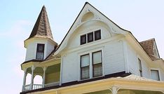 a large white house with two towers on it's roof and an arched window