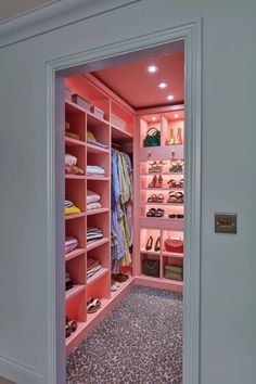 an open closet with pink shelves and shoes