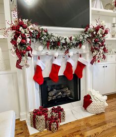 christmas stockings hung over the fireplace decorated with red, white and silver stocking decorations