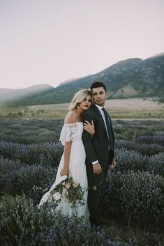 a bride and groom standing in a lavender field