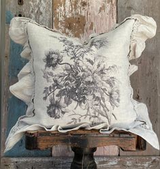 a pillow with flowers on it sitting on top of a wooden bench