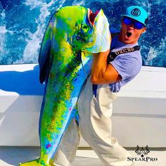 a man holding a large fish on the back of a boat