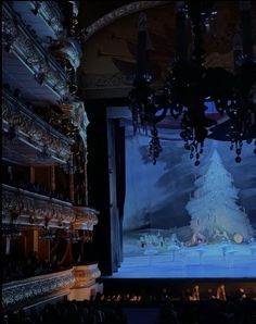 the stage is lit up with chandeliers and snow - covered trees on it