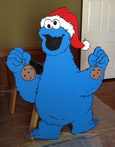 a cardboard cut out of cookie monster with a santa hat on it's head