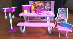 there is a pink table with chairs and pictures on it