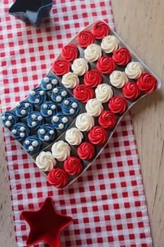 an american flag shaped cupcake on a red white and blue checkered tablecloth