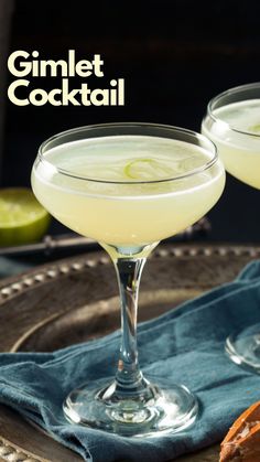 two glasses filled with cocktail sitting on top of a table