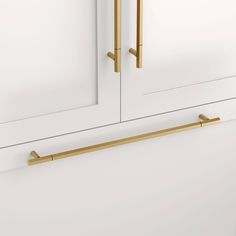 a white cabinet with two brass handles on it