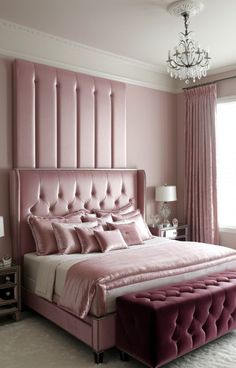 a bedroom with pink walls and a bed in the middle, along with a chandelier