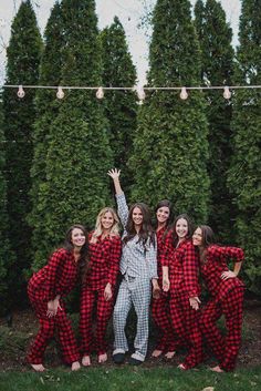 a group of women in red and black pajamas posing for the camera with their arms up