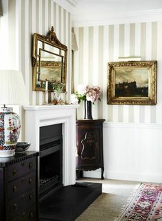 a living room filled with furniture and a fire place in front of a painting on the wall