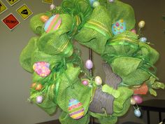 a green wreath with easter decorations on it