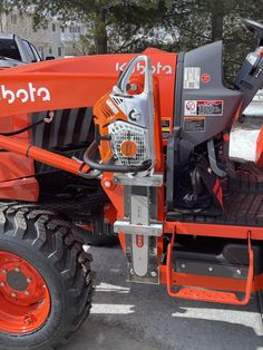 an orange tractor parked in a parking lot