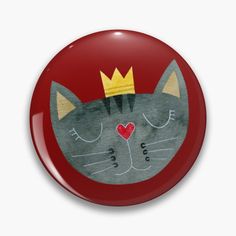 a red button with a cat wearing a crown on it's head and eyes closed