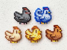 four pixelated chicken magnets are shown on a white surface, each with different colors and sizes