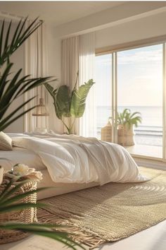 a bed with white sheets and pillows in front of a large window overlooking the ocean