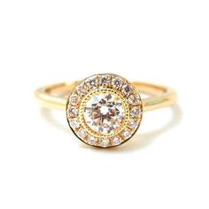 a yellow gold ring with a diamond center