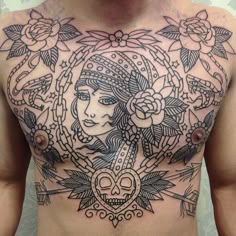 a man's chest with tattoos on it and flowers in the middle of his chest