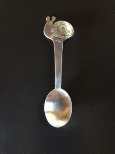 a spoon with a metal handle on a black surface