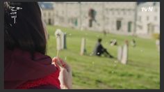 a woman blowing bubbles in front of an old building with people on the other side