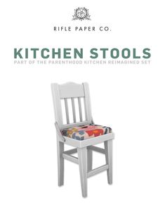 the kitchen stool is made from white wood and has colorful fabric on it's seat