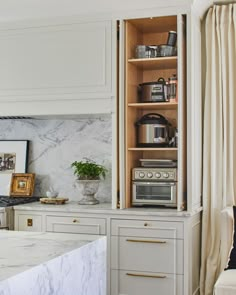 a kitchen with marble counter tops and white cabinets