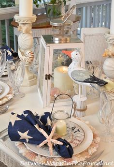 a white table topped with plates and candles