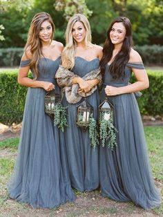 three beautiful women in long dresses standing next to each other