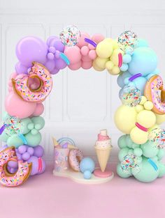 a balloon arch with donuts, ice cream and sprinkles