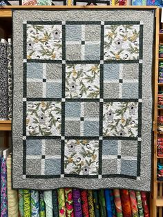 a quilted wall hanging in front of many different fabrics