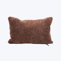 a brown pillow sitting on top of a white wall