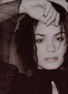 a black and white photo of a woman with her hair pulled back in a ponytail