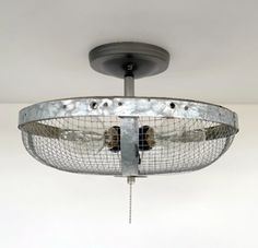 a ceiling fan that is hanging from the ceiling in a room with white walls and flooring