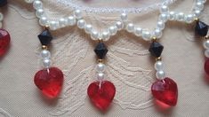 the necklace has hearts and pearls on it