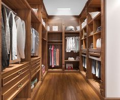 a walk - in closet with wooden shelves and drawers filled with clothes, shoes and other items