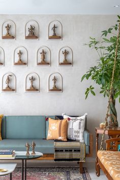 a living room filled with lots of furniture next to a wall covered in shelves and sculptures